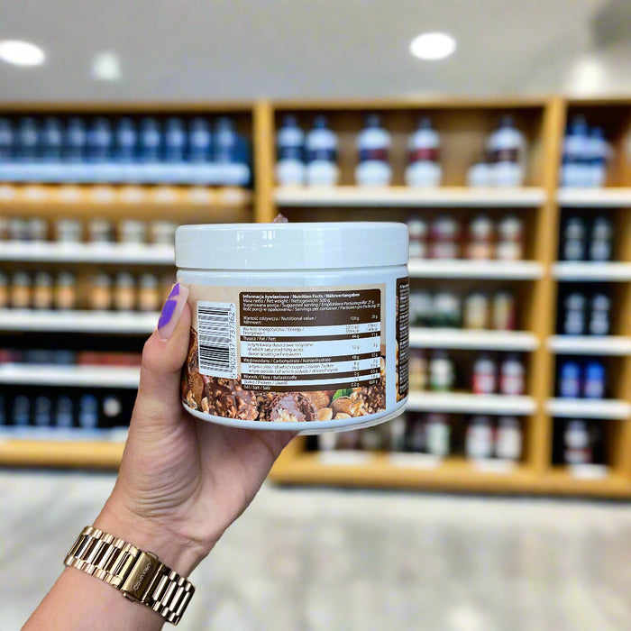 Close-up of (Allnutrition Nutlove 500g) held up inside My Supplement Shop, clearly showing Nutritional Values on the packaging in a Sports Nutrition setting.